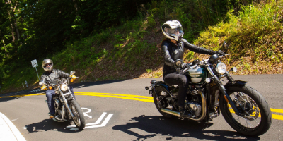 2 motorcyclists driving on road