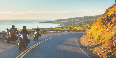 three motorcyclists driving down winding road