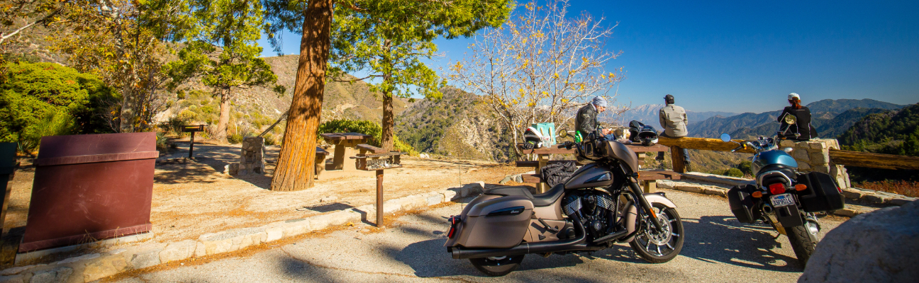 motorcycles hanging out by scenic view.