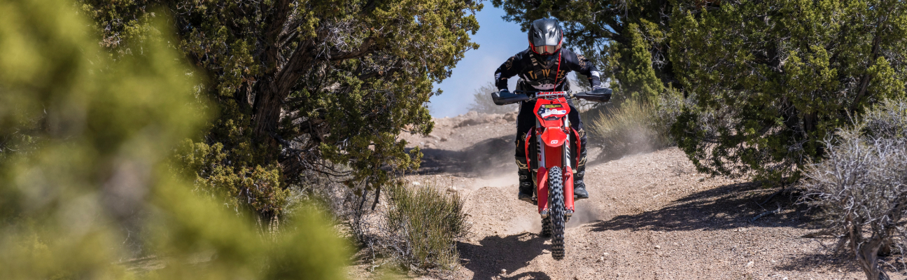 Motorcyclist driving down dirt bath